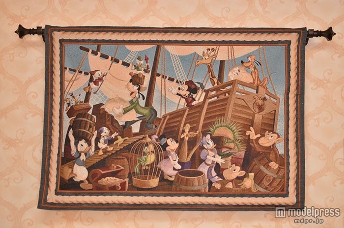 荷物を運ぶ様子を描くタペストリー