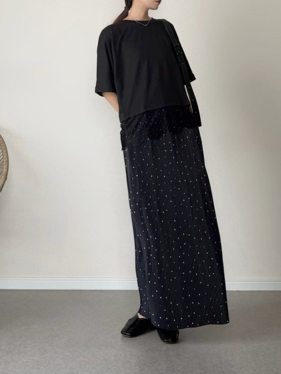 黒いトップスとドット柄ナロースカートを着用した女性 黒いトップスとドット柄ナロースカートを着用した女性