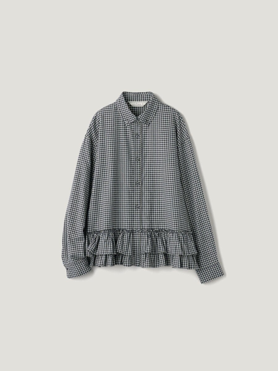 白黒のギンガムチェック柄長袖シャツ。裾に二段のフリルがあしらわれている。