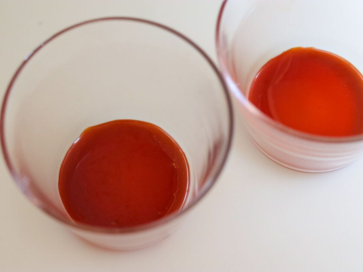 ガラスのプリンカップの底にカラメルソースを注いだ俯瞰写真