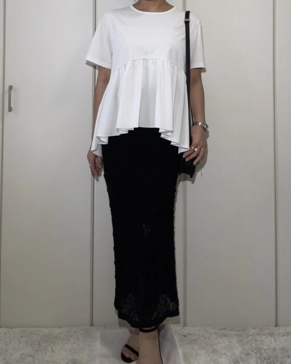 白いTシャツに黒いレースのナロースカートを合わせた女性の全身