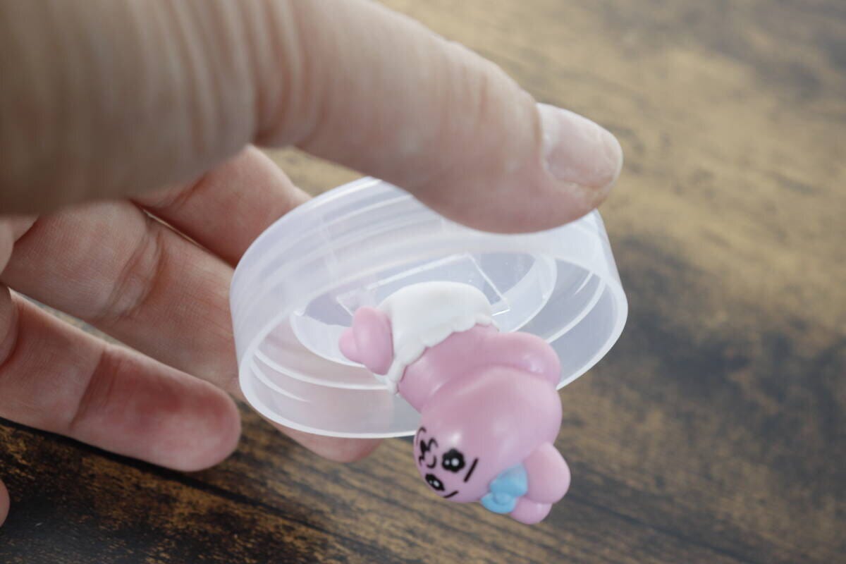 ピンクのマスコットが貼り付けられた蓋を逆さまにしても落ちない