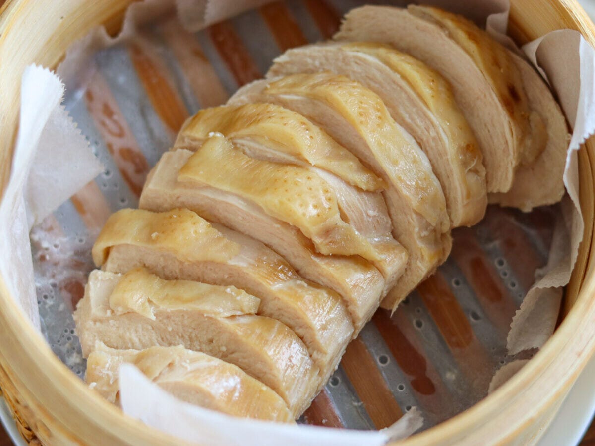 木製のせいろの中に蒸し上がった鶏むね肉が皮を上にしてスライスされ並んでいる俯瞰写真
