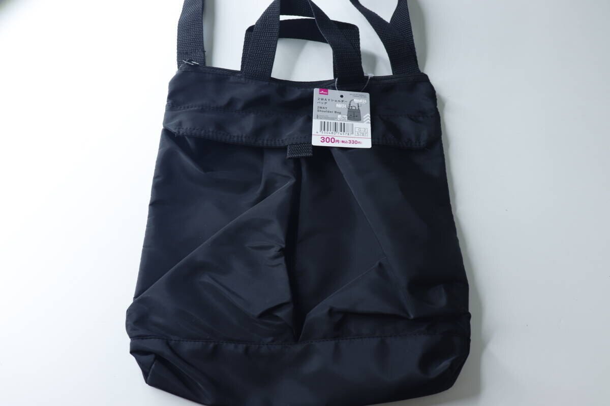 黒い2WAYショルダーバッグが白い背景に置かれ、商品タグが付いている状態 黒い2WAYショルダーバッグが白い背景に置かれ、商品タグが付いている状態