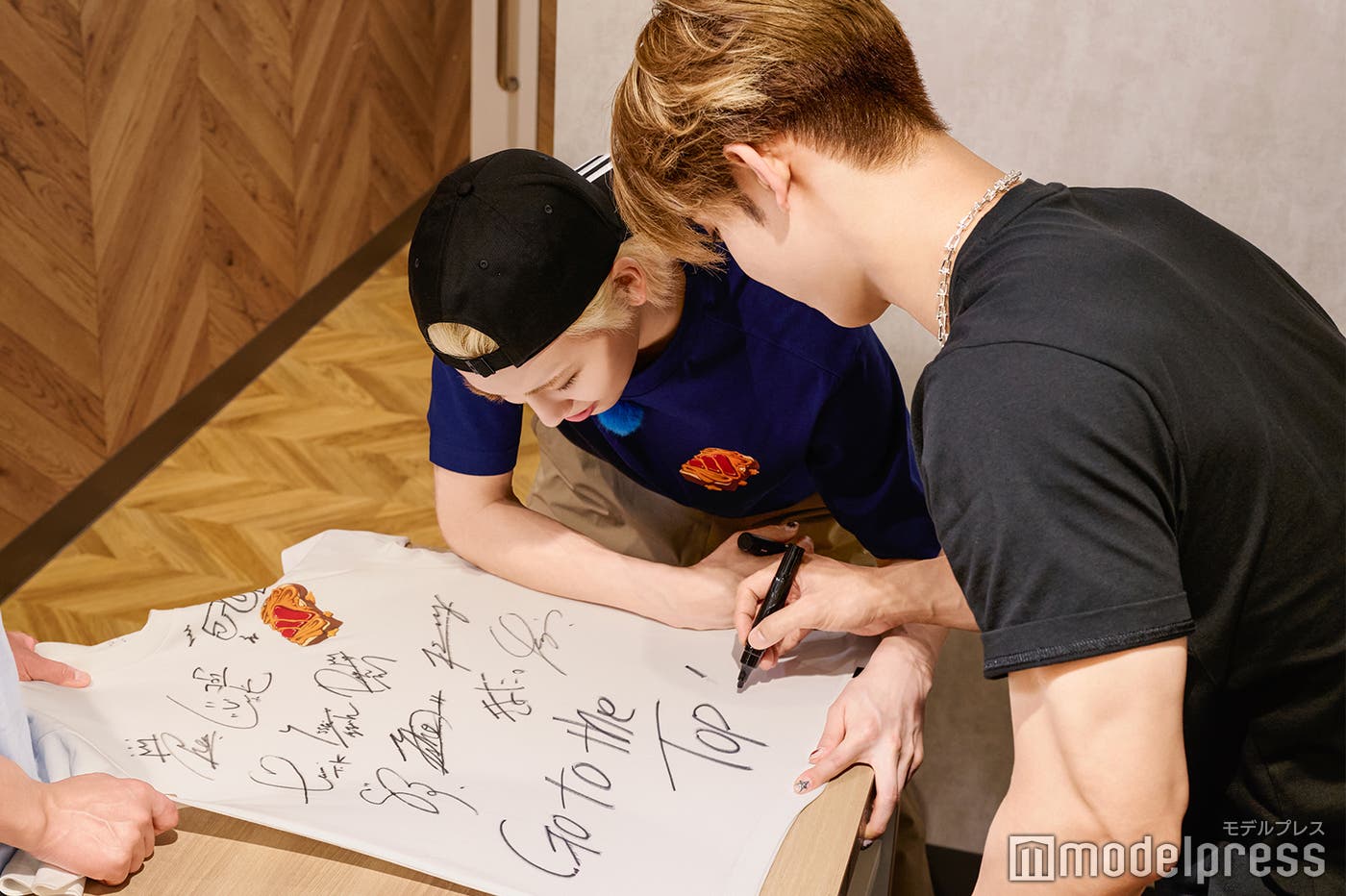 共同作業でサイン入れをする與那城奨と川尻蓮(C)モデルプレス
