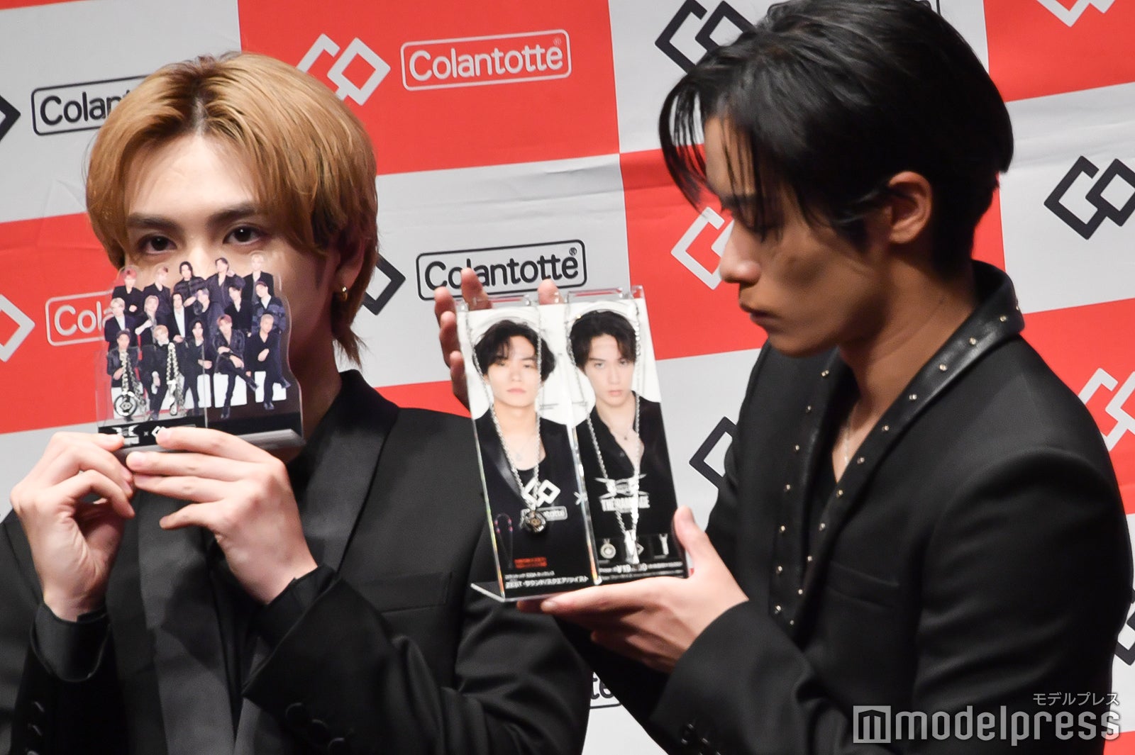 グッズで顔を隠す吉野北人、グッズが気になる川村壱馬（C）モデルプレス