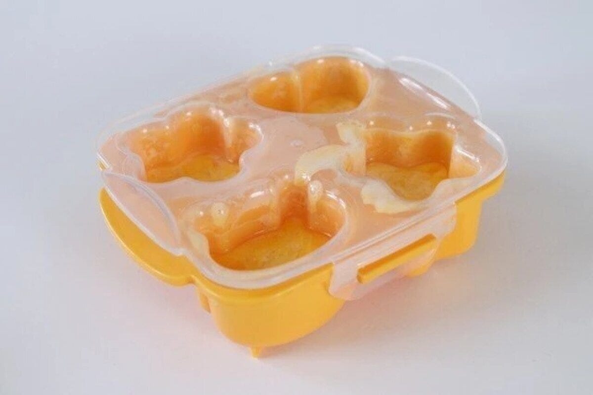 オレンジのシリコン型4枠に溶き卵を入れ透明な蓋をした電子レンジ加熱前の状態