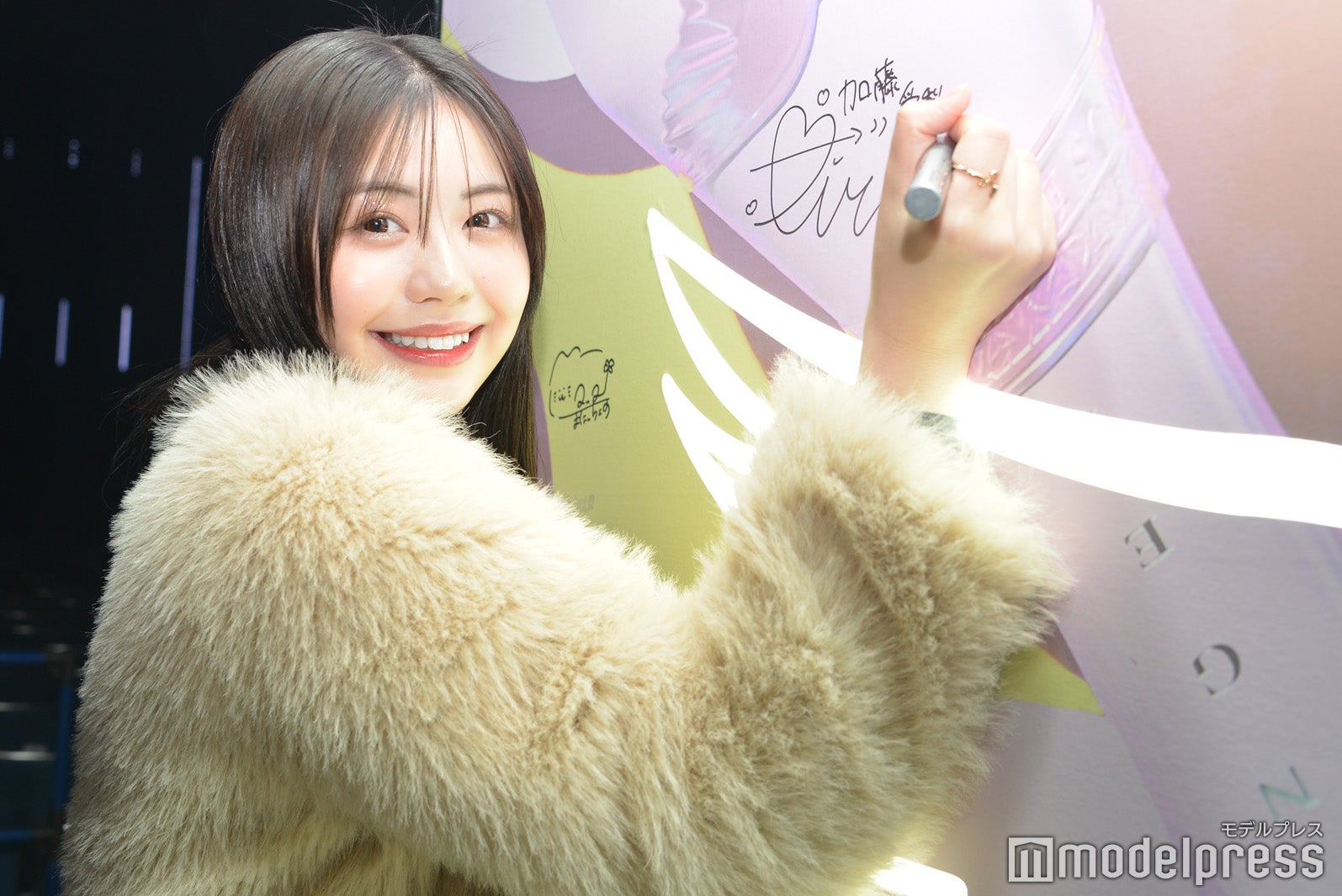 「ANGEL CHAMPAGNE」パネルにサインを書く加藤愛梨（C）モデルプレス