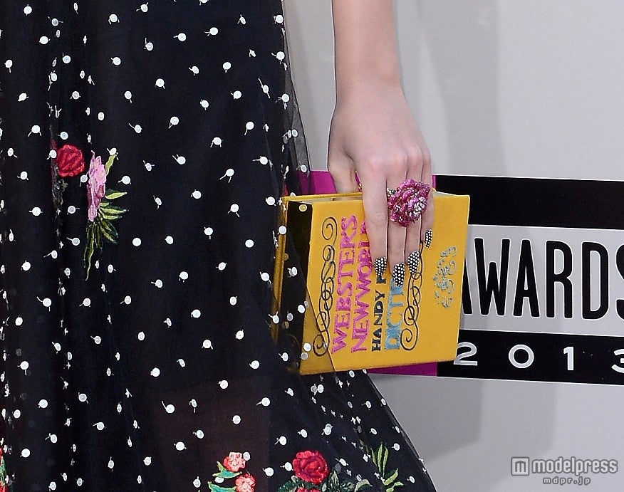 ドレスに合わせてネイルも水玉柄。本型のバッグもカワイイ。Newscom / Zeta Image