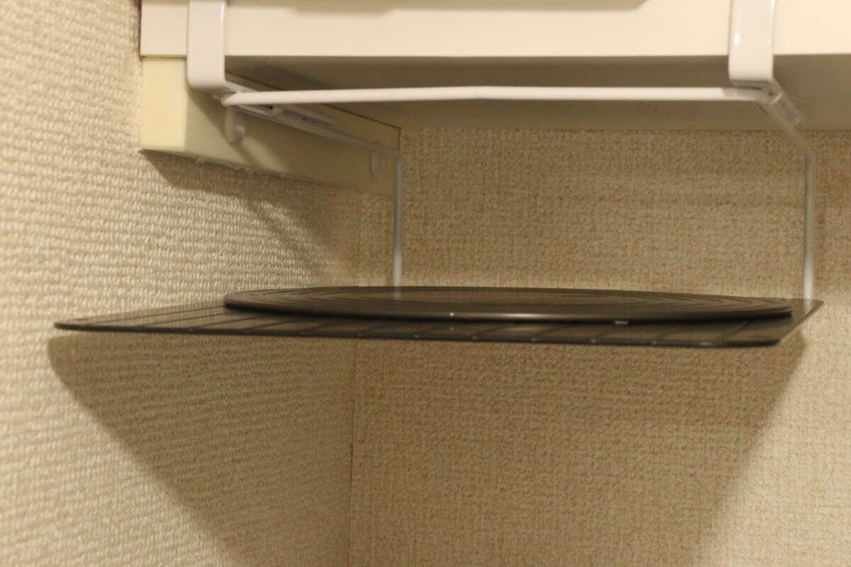 吊り戸棚ラックに黒い丸いまな板を収納している様子 吊り戸棚ラックに黒い丸いまな板を収納している様子