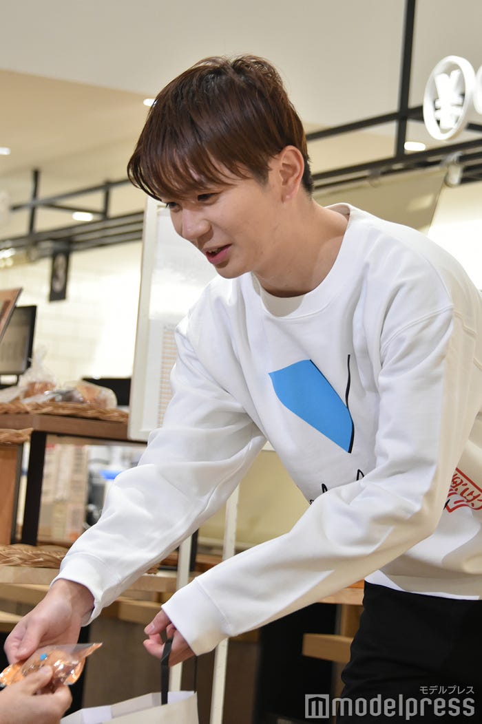 取材陣に「塩バニラフィナンシェ」を配る高橋優斗(C)モデルプレス