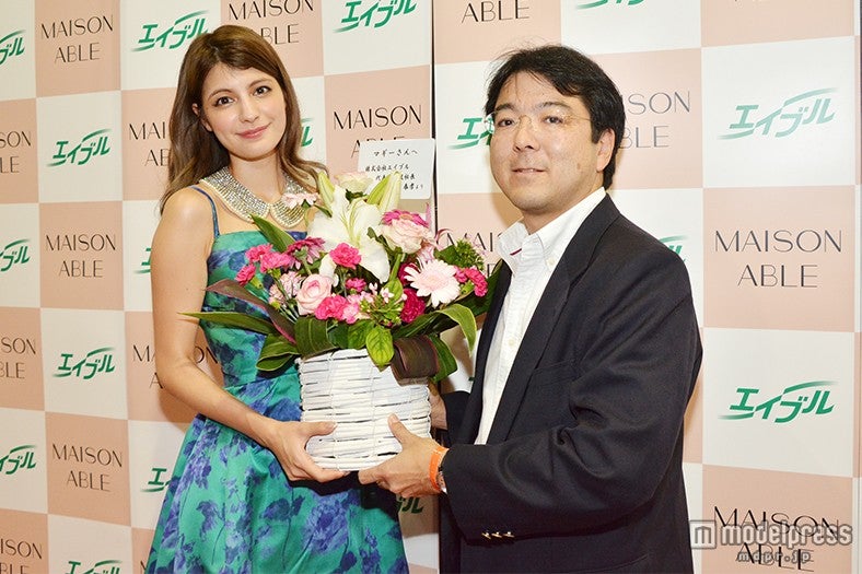 花束を受け取るマギー（左）／「MAISON ABLE」ブース