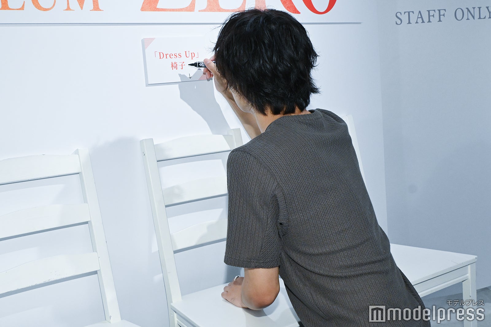 倒した椅子の説明を書く太田将熙（C）モデルプレス