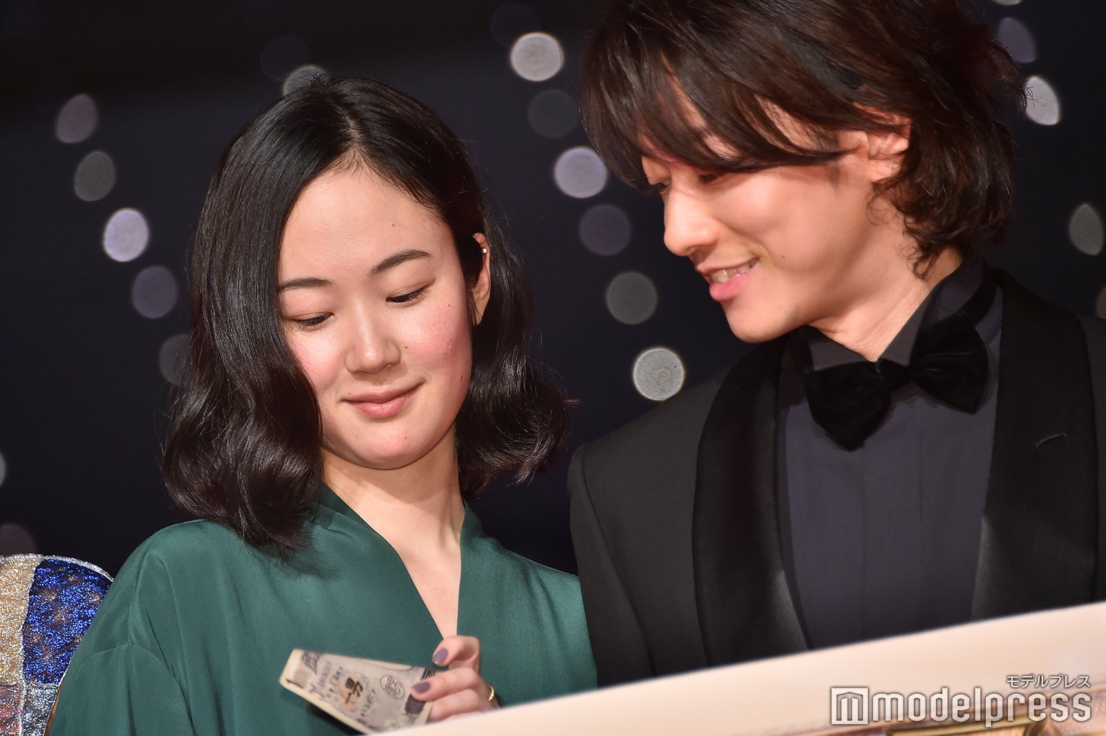 “「億男」特製紙幣”を眺める黒木華、佐藤健 （C）モデルプレス