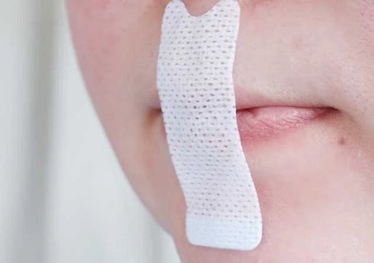 女性の口元に白いマウステープが貼られている