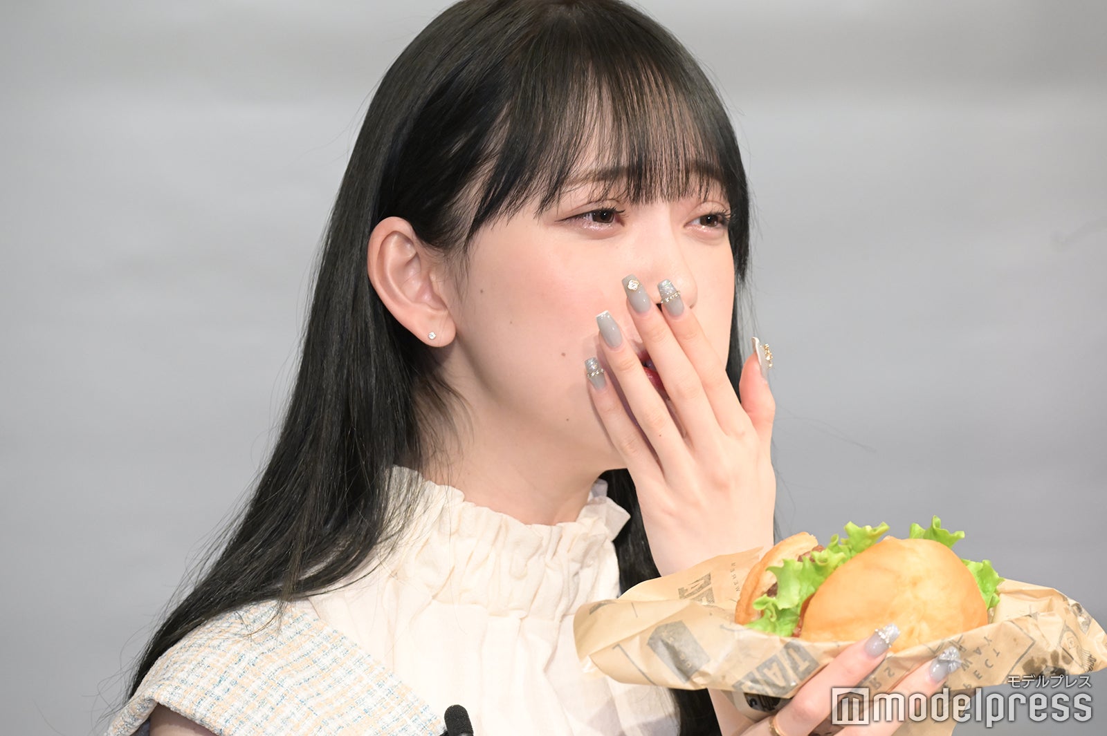 自身でカスタマイズしたハンバーガーを頬張る堀未央奈（C）モデルプレス