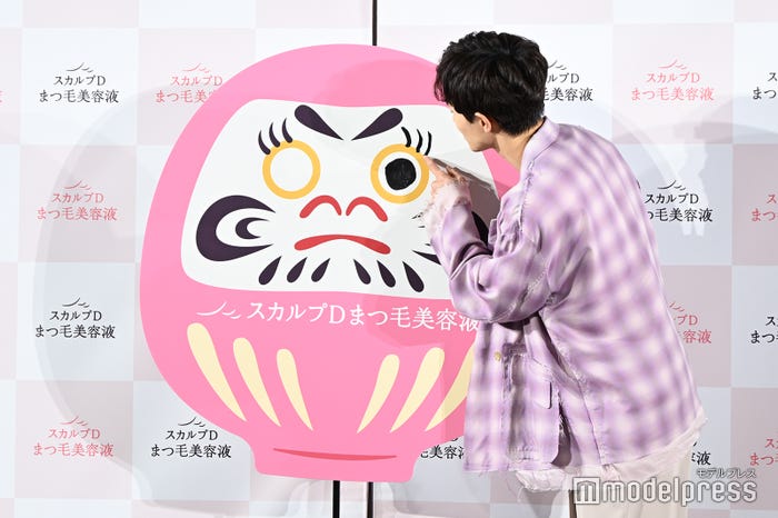 あまり載せてほしくないだるまを描く草川拓弥(C)モデルプレス