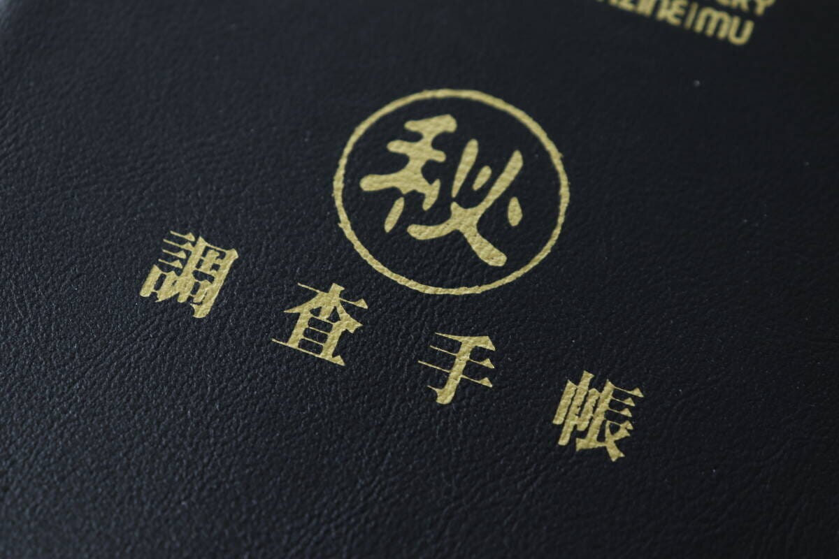 ムーのレザー調ノートの表紙に施されたゴールドの箔押し「秘」「調査手帳」の文字のクローズアップ ムーのレザー調ノートの表紙に施されたゴールドの箔押し「秘」「調査手帳」の文字のクローズアップ