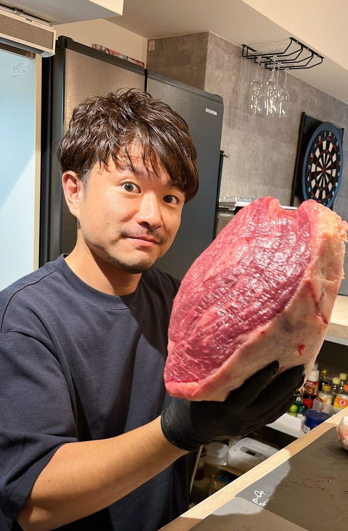 肉会で肉塊をメンバーに振る舞う井上真生氏(提供画像)