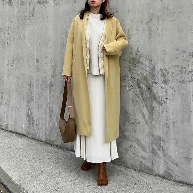 レディース大人冬ロングイエローコートと白プリーツスカートコーデ