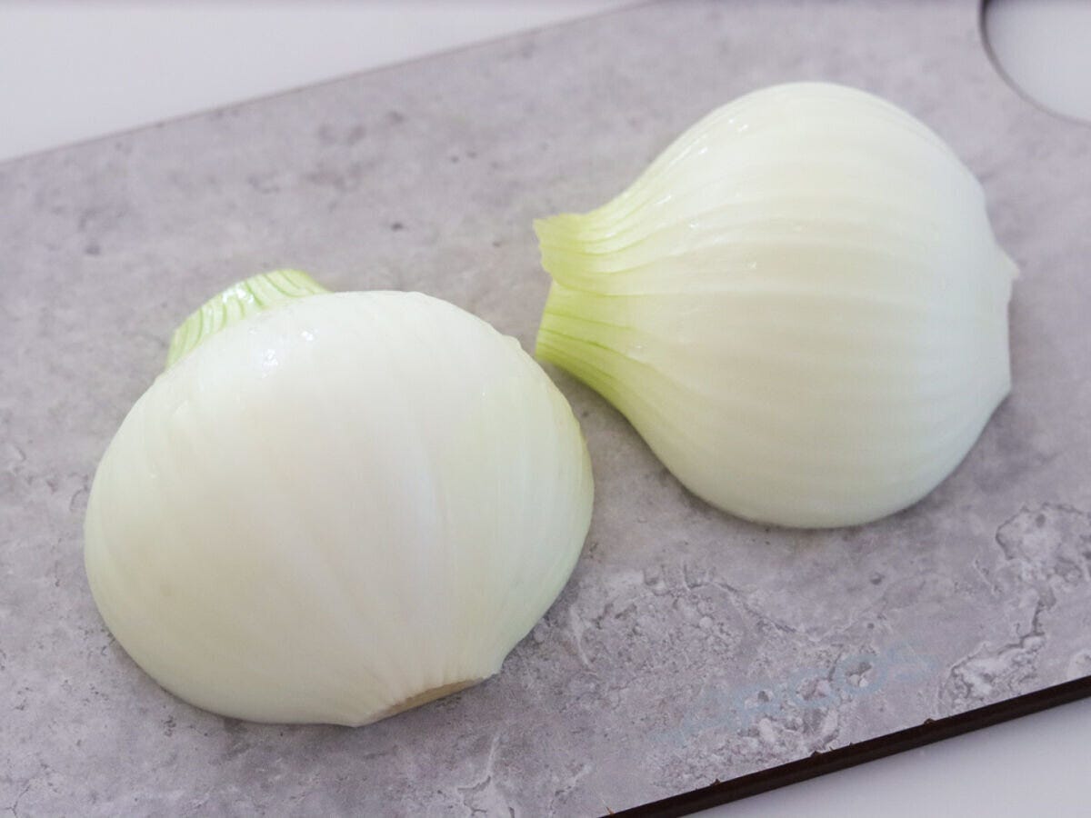 皮をむいて縦半分に切った新玉ねぎ 皮をむいて縦半分に切った新玉ねぎ