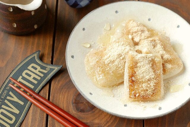 お餅を皿に盛り、きな粉をかけてはちみつを垂らす