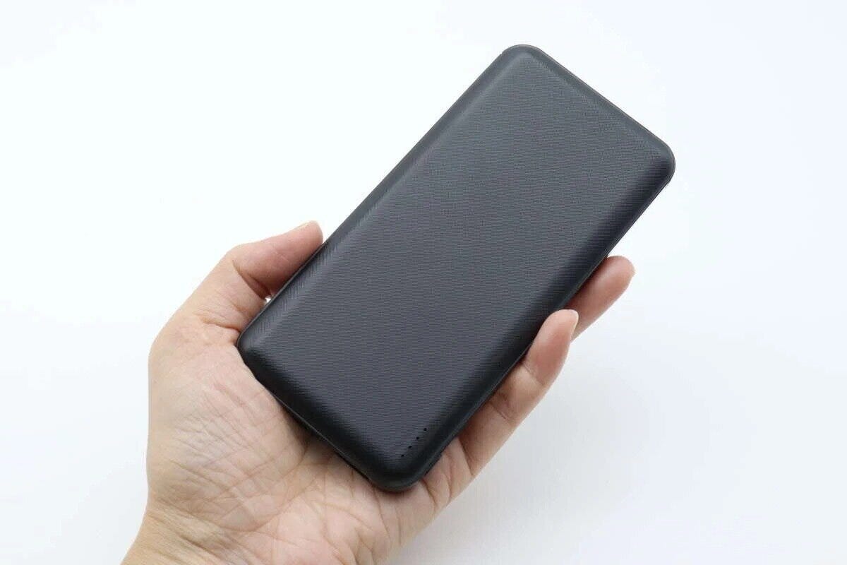 女性の手のひらに乗せられた黒いモバイルバッテリー 女性の手のひらに乗せられた黒いモバイルバッテリー