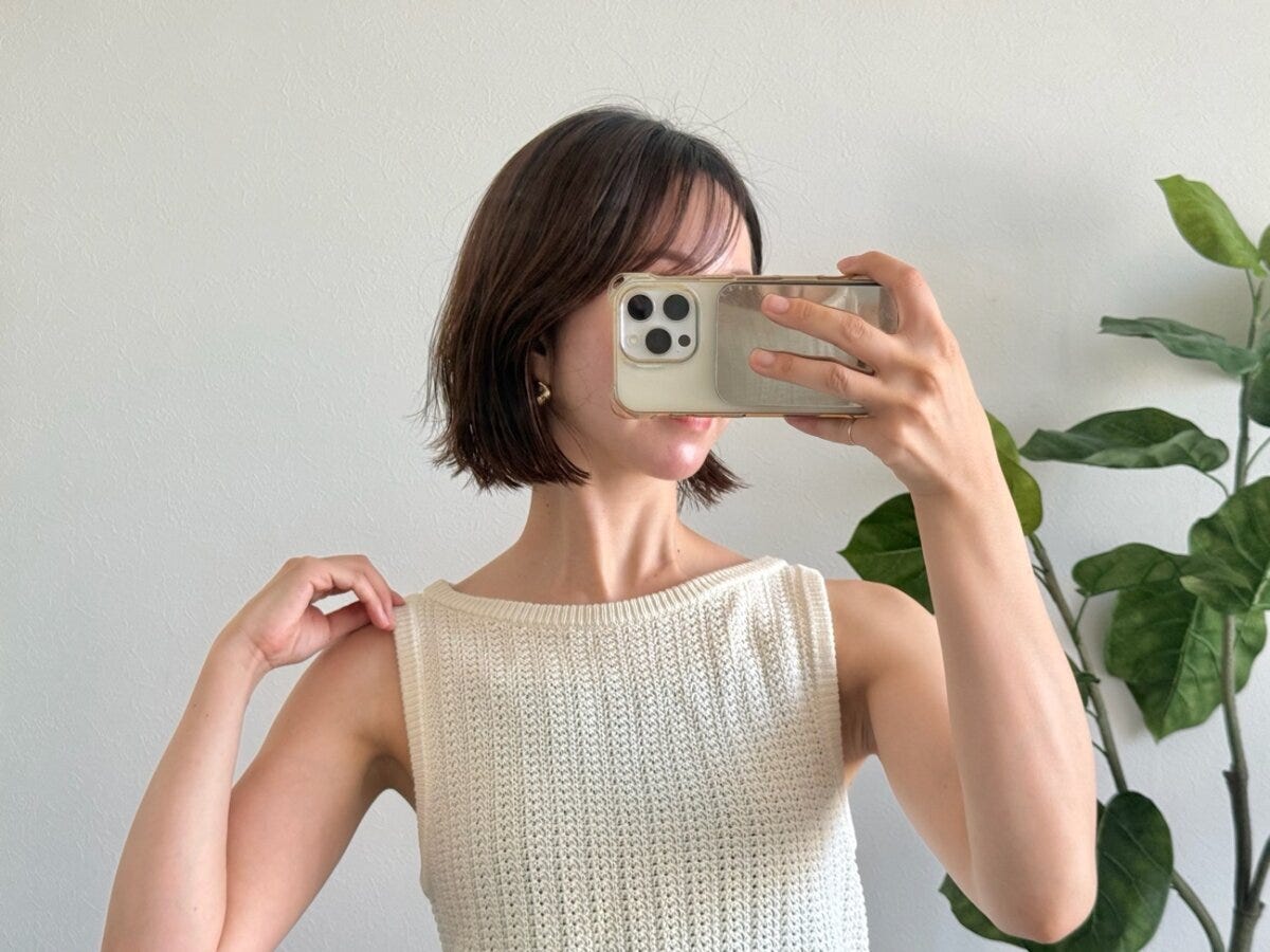 白いニットタンクトップを着た女性が肩を見せている 白いニットタンクトップを着た女性が肩を見せている