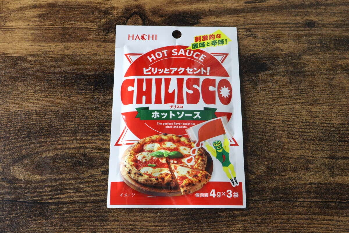 木目のテーブルに置かれたチリスコホットソースのパッケージ
