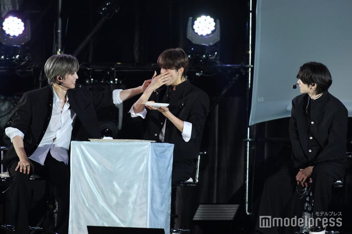 優しく見守るFUMA、みかん大福をまるごと食べてしまい喋れないEJ、ちょっと心配そうなYUMA(C)モデルプレス