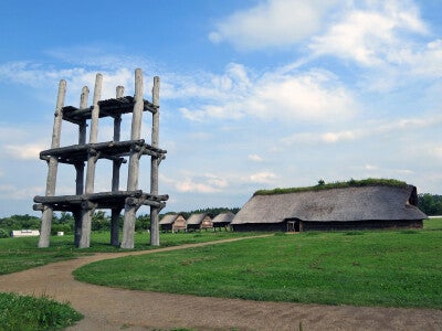 三内丸山遺跡、六本柱の大型掘立柱建物（左。復元）と大型竪穴建物（右。復元）。両者の間には高床建物も見える