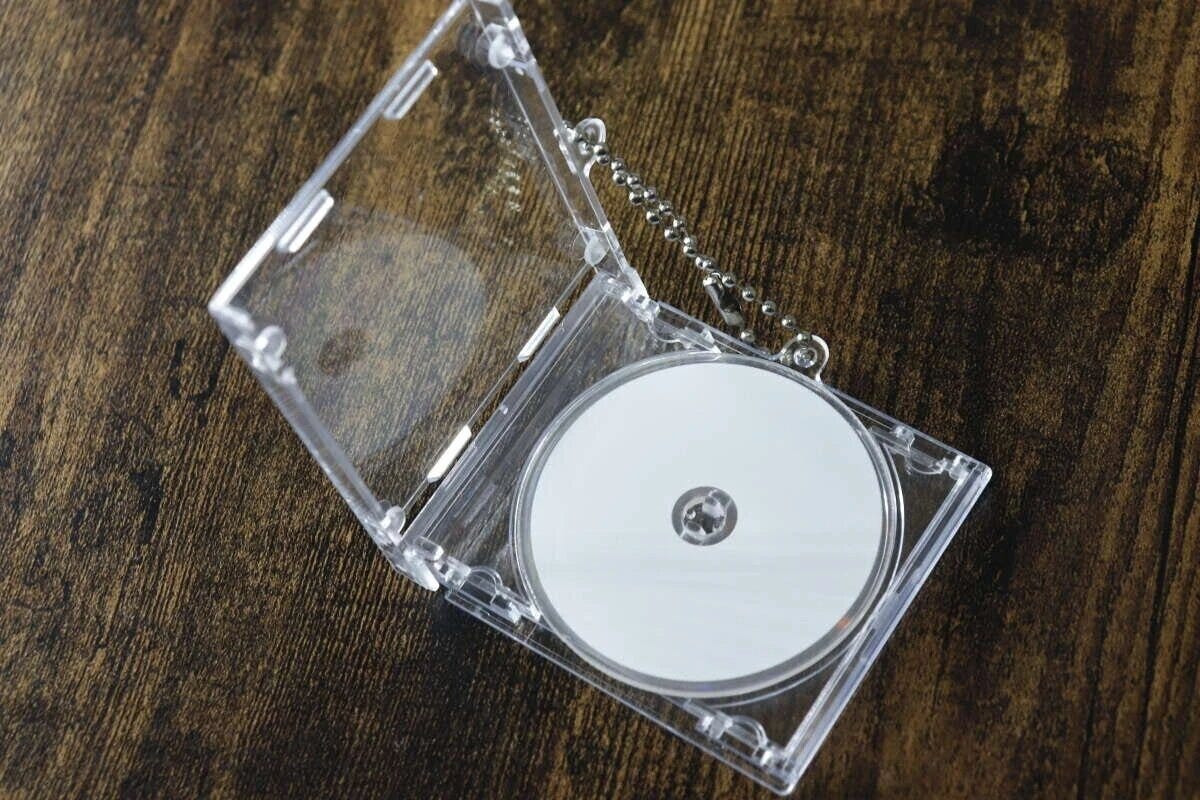 透明なCDケース型キーホルダーが開いて中に白いCDが入っている