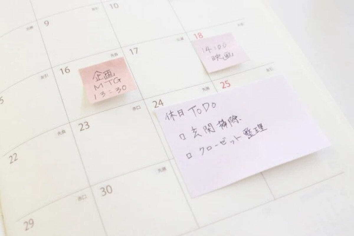 手帳に貼られたピンクのふせんに予定やToDoリストが書かれている 手帳に貼られたピンクのふせんに予定やToDoリストが書かれている