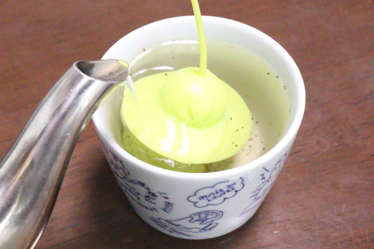 カップに入れたティーストレーナーにやかんからお湯を注いでいる様子 カップに入れたティーストレーナーにやかんからお湯を注いでいる様子