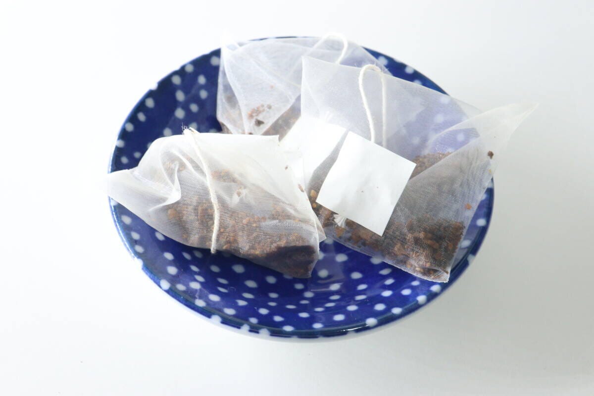 青い水玉模様の小皿に白いティーバッグが3つ並べられている 青い水玉模様の小皿に白いティーバッグが3つ並べられている
