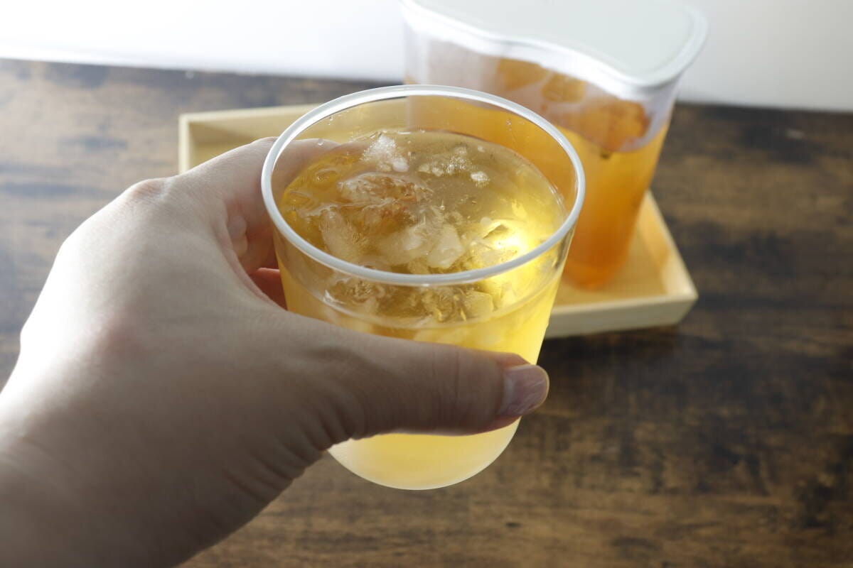 氷と飲み物が入ったグラスを手に持っている様子