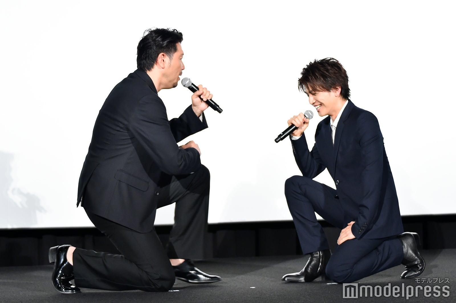 岩田剛典（右）にひざまずく別所哲也（左）（C）モデルプレス