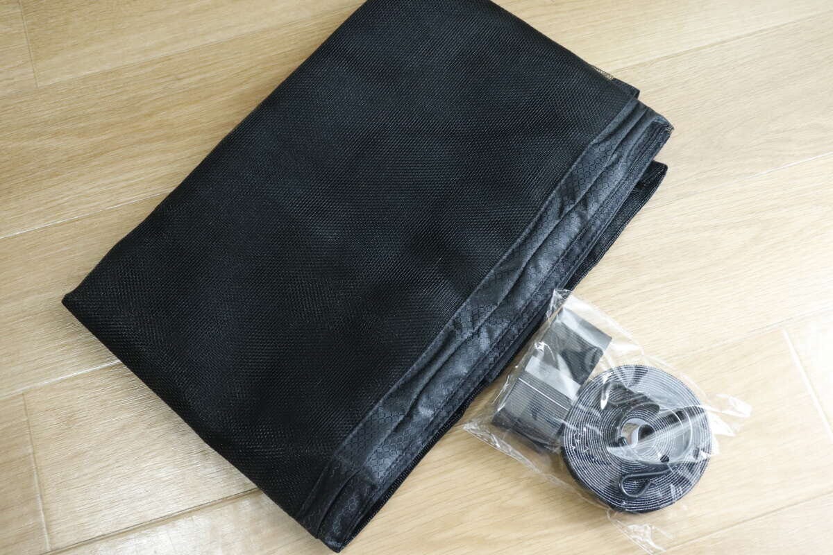 開封された黒い網戸ネットと、袋に入った面ファスナーなどの付属品