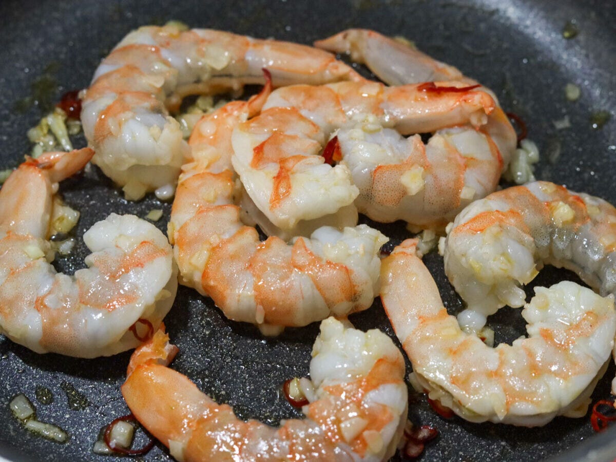 フライパンでエビを炒めて赤く色づいてきた様子