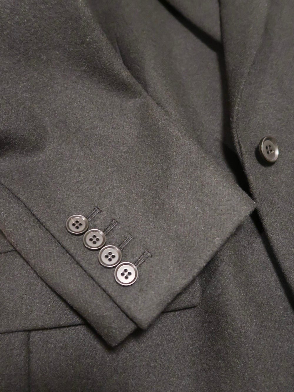 袖のボタンは4個。落ち着いた印象で着られます