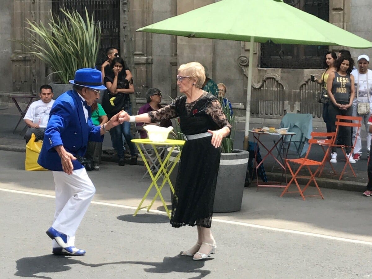 路上で音楽に合わせて踊るステキなカップル