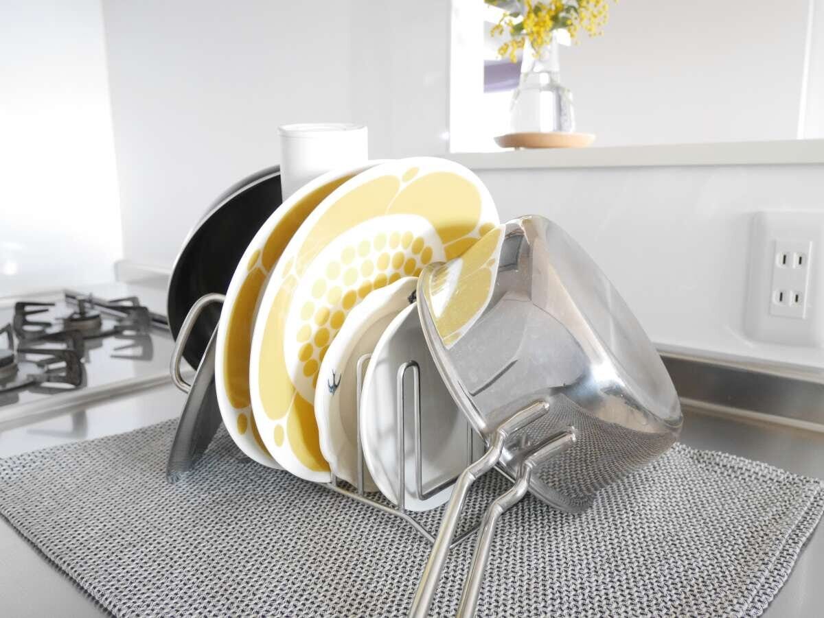 ティータオルの上にキッチンスタンドを置きお皿や鍋蓋を立てて乾かしているカウンターの様子 ティータオルの上にキッチンスタンドを置きお皿や鍋蓋を立てて乾かしているカウンターの様子