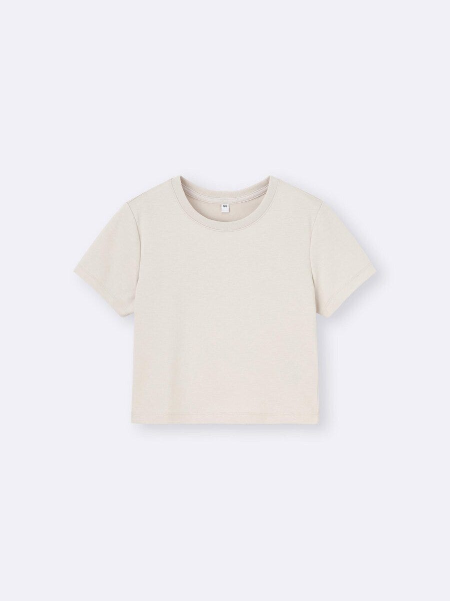 ベージュのミニ丈Tシャツを平置きで撮影。シンプルなクルーネック。