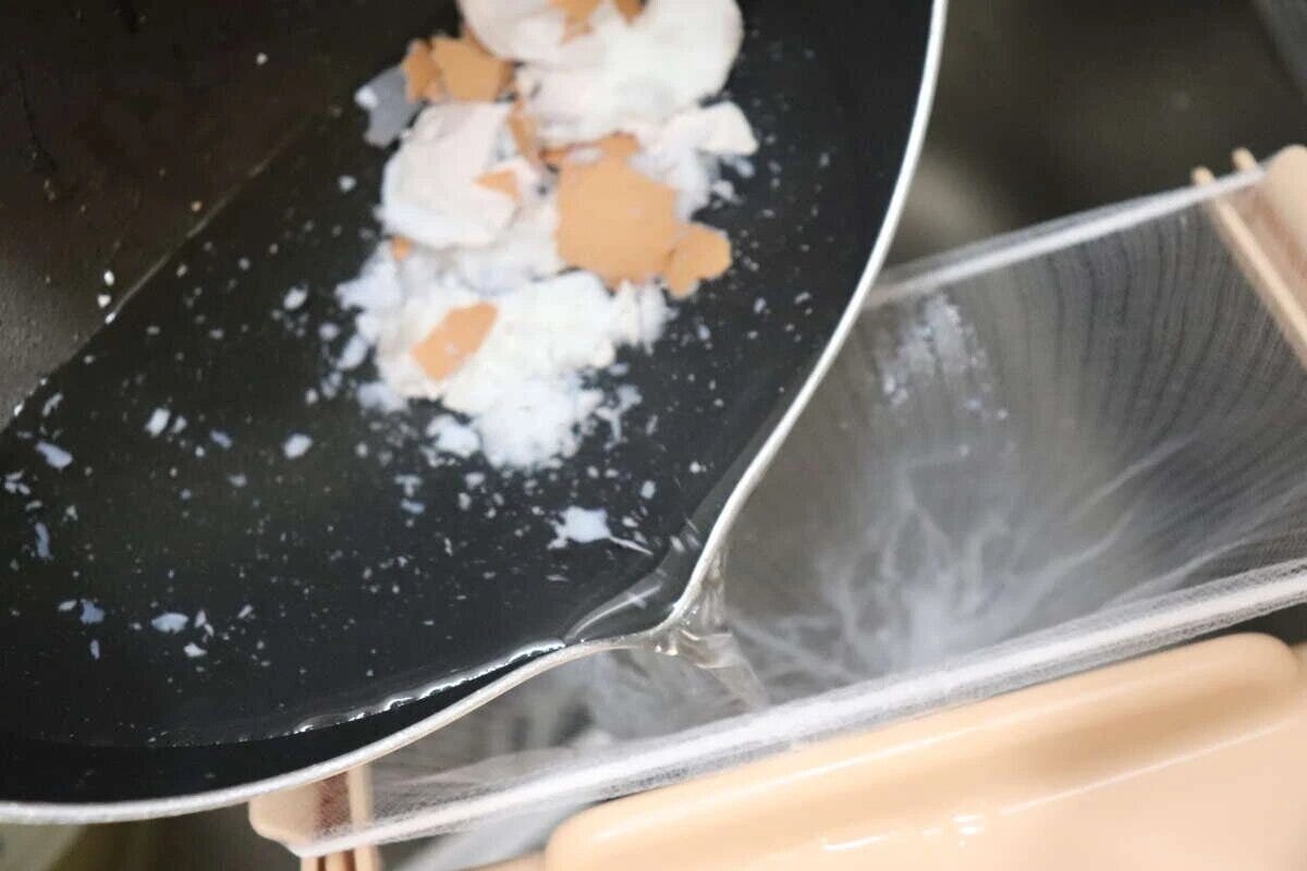 水切りネットをセットしたホルダーに鍋から水と生ゴミを流す様子 水切りネットをセットしたホルダーに鍋から水と生ゴミを流す様子