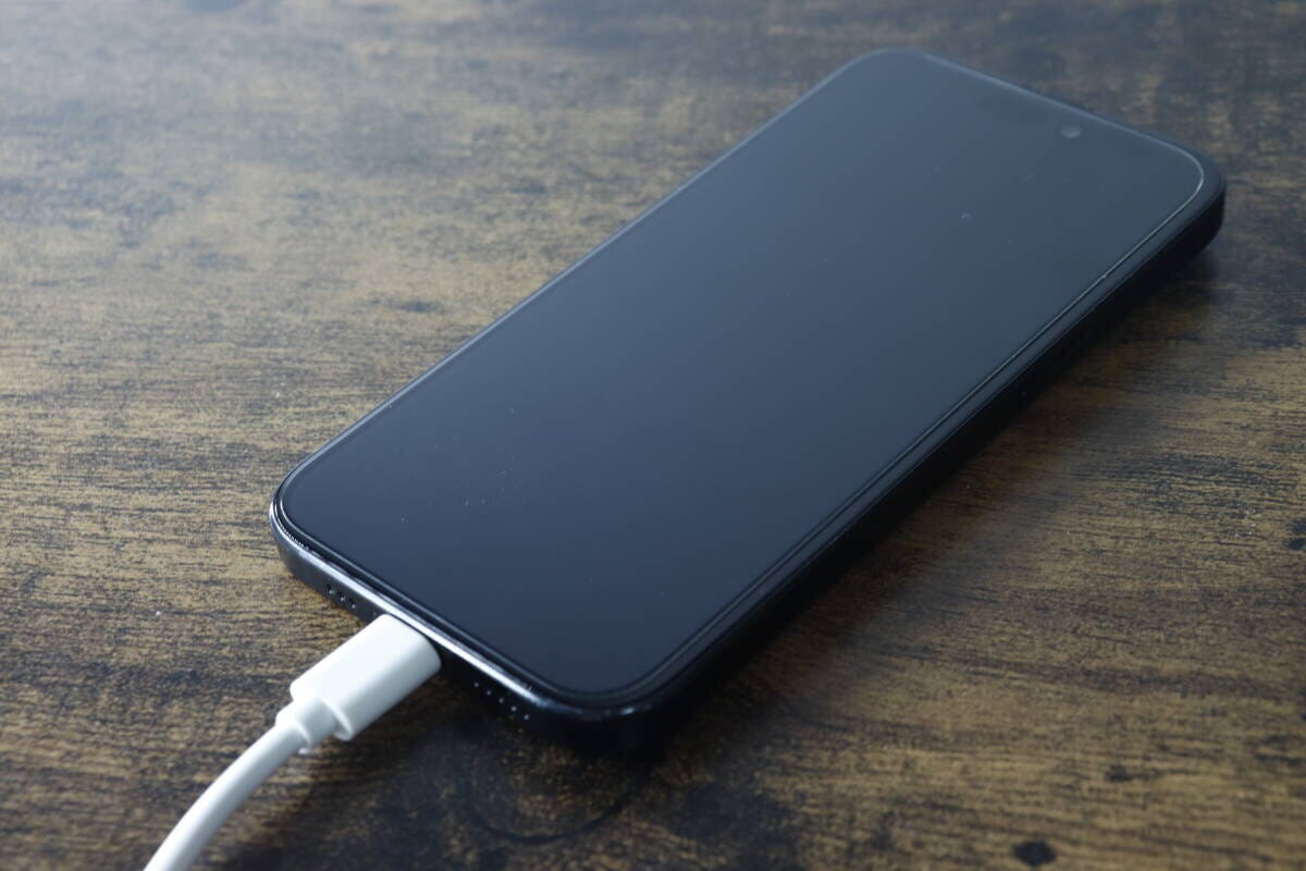 黒いスマートフォンに白いType-C充電ケーブルを接続している 黒いスマートフォンに白いType-C充電ケーブルを接続している
