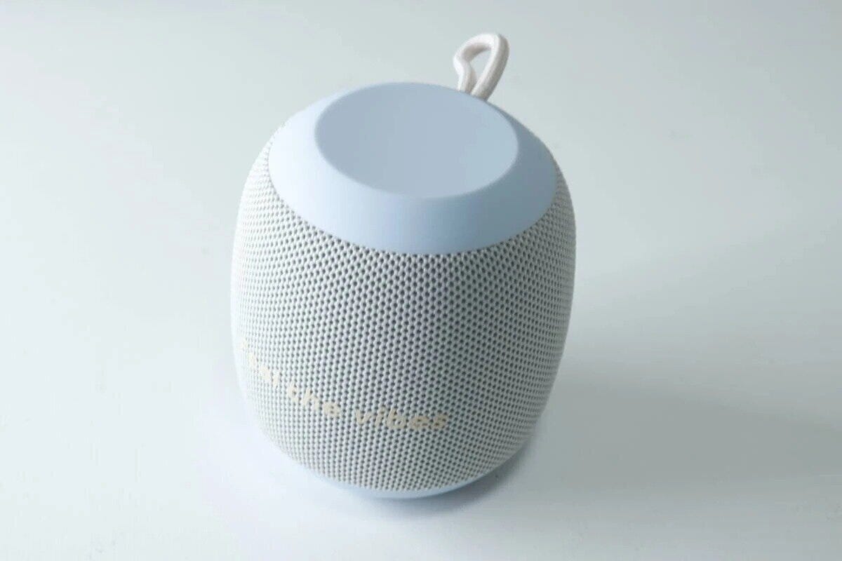 水色と白の丸いBluetoothスピーカーが白背景に置かれている 水色と白の丸いBluetoothスピーカーが白背景に置かれている