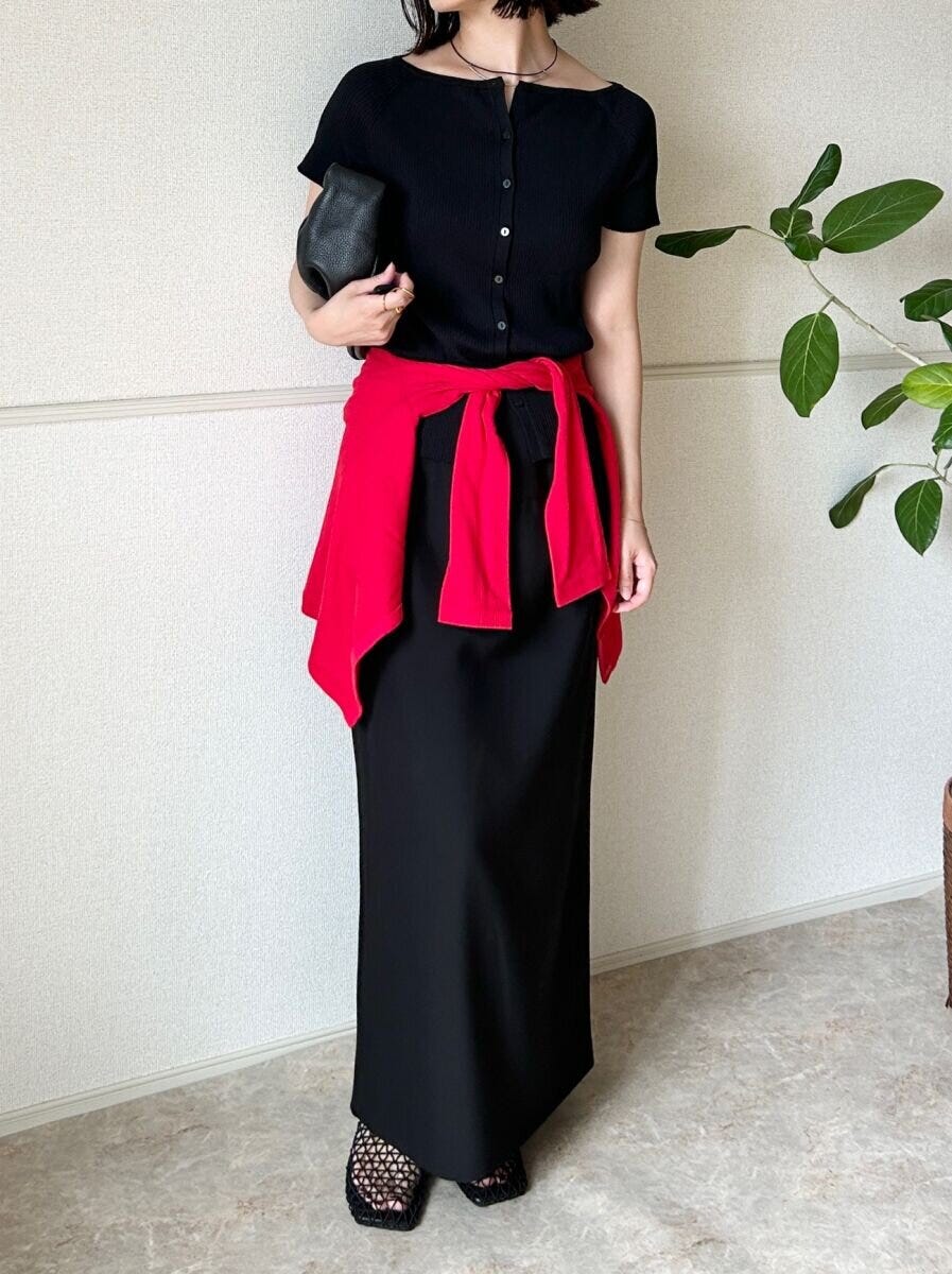 黒カーデと黒スカートに赤いカーデを腰巻きした女性 黒カーデと黒スカートに赤いカーデを腰巻きした女性