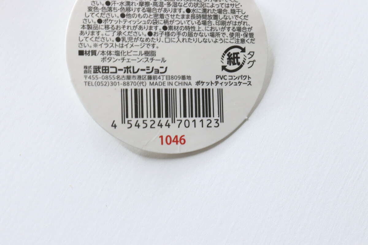 ポケットティッシュケースの商品タグの裏面。JANコードや素材、注意書きが記載されている