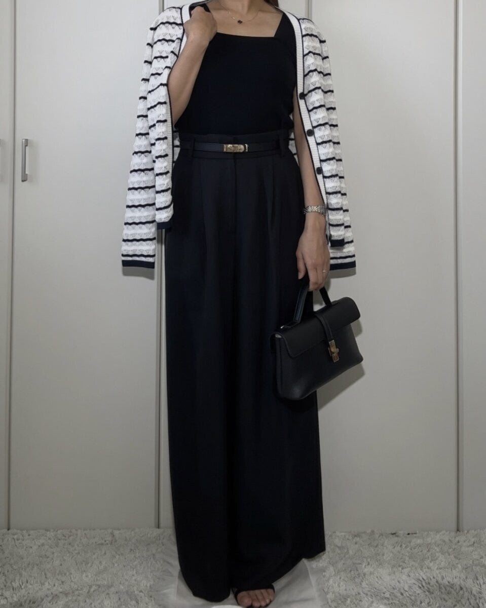 黒いニットインナーとワイドパンツにボーダーカーディガンを羽織りバッグを持つ女性 黒いニットインナーとワイドパンツにボーダーカーディガンを羽織りバッグを持つ女性