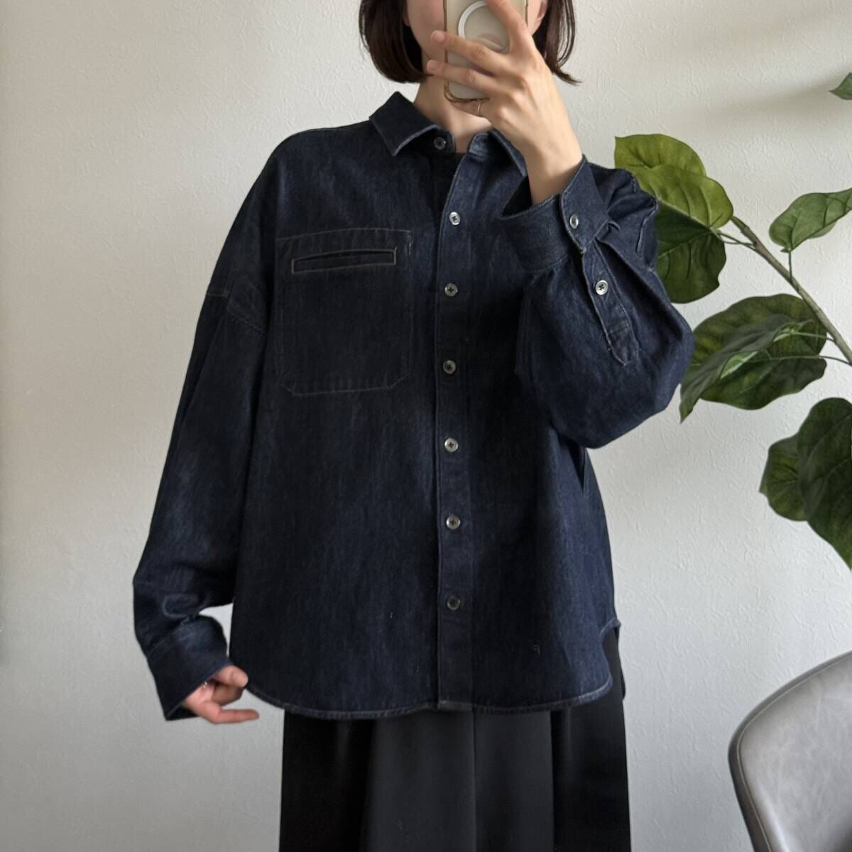 女性がデニムシャツジャケットのボタンを閉めて自撮り 女性がデニムシャツジャケットのボタンを閉めて自撮り